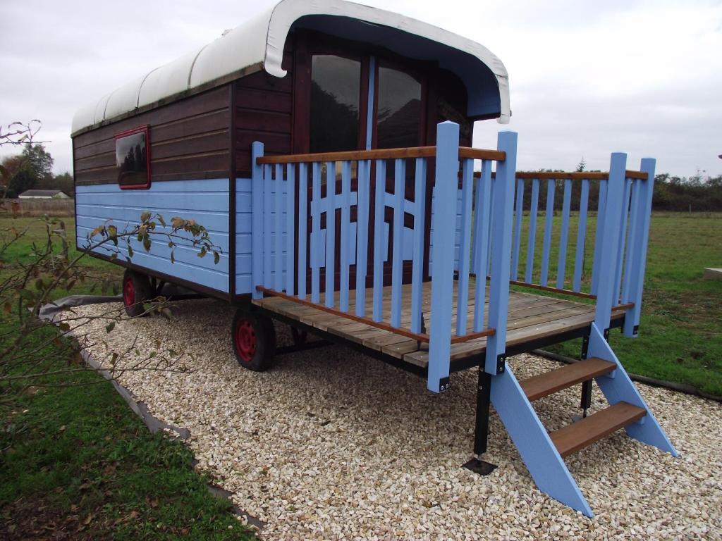 a small blue train playground with a bench at La Roulotte des Amis in Ousson-sur-Loire