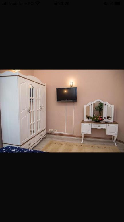 a living room with a tv and a white cabinet at Zara Central Apartments in Arad