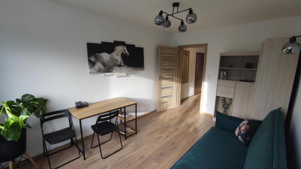 a living room with a blue couch and a table at Apartament Gagarina in Gliwice
