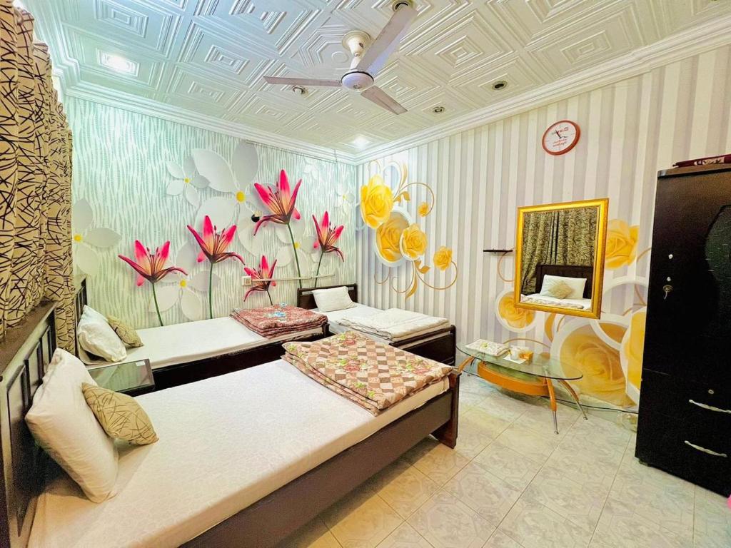 1 dormitorio con cama y pared de flores en Venus Guest House, en Hyderabad