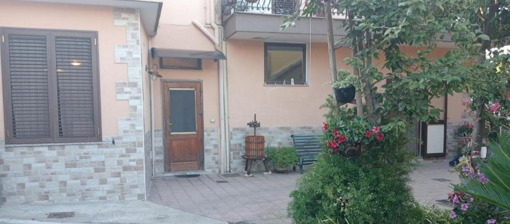 a house with a door and a bench and flowers at Casa David in Cava deʼ Tirreni