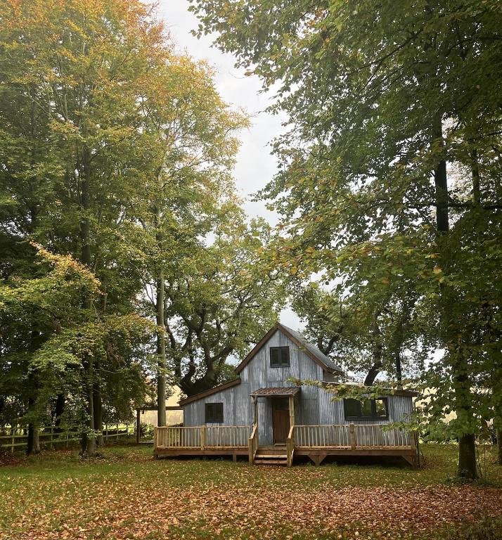 a small barn with a porch and a deck at Moonshine in Grimston