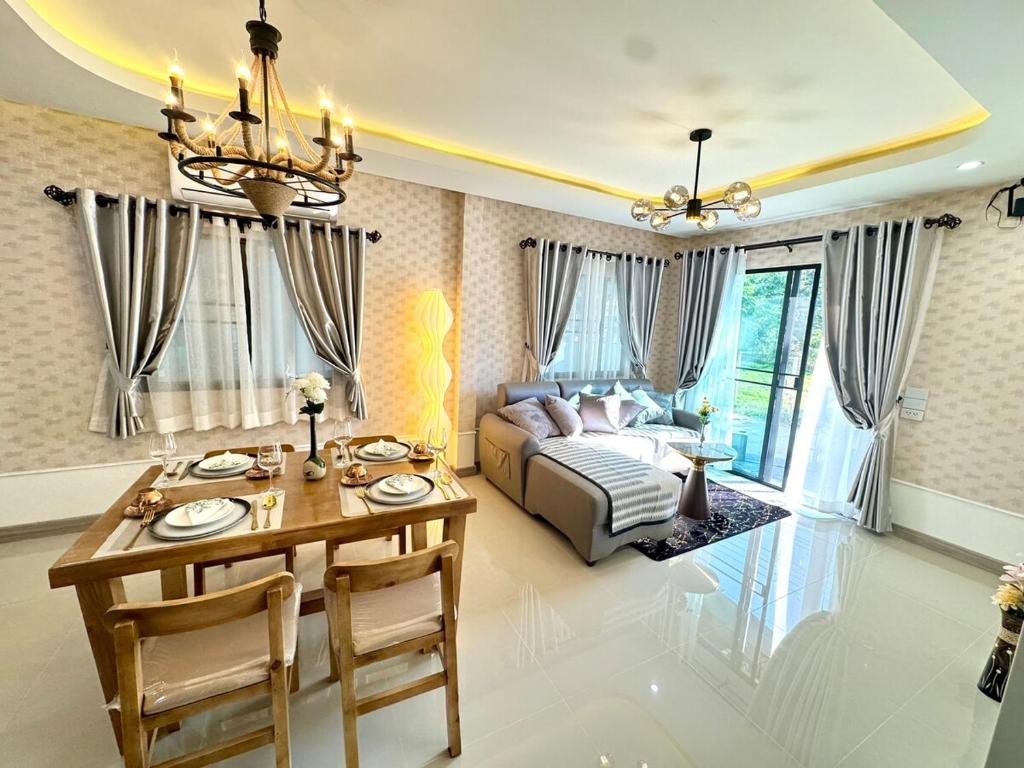 Un dormitorio con una cama y una mesa y un comedor. en Check it Near Panyaden,SBS,Kad Farang,13min to airport, en Hang Dong