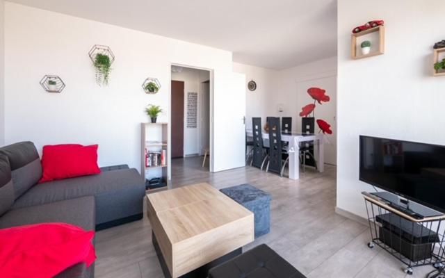 un salon avec un canapé, une télévision et une table dans l'établissement Lhuisne, au Mans