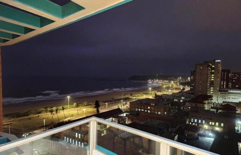 a view of the beach at night from a balcony at 10 South Ocean Views in Durban