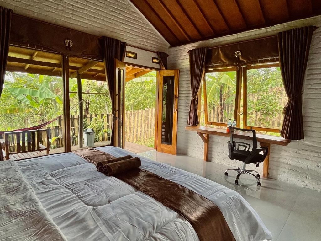 a bedroom with a large bed and large windows at Mimi homestay-LOMBOK in Tetebatu