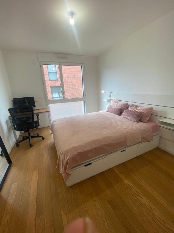 une chambre avec un lit avec des oreillers roses dessus dans l'établissement Charmant F2 près D'Orly, à Choisy-le-Roi