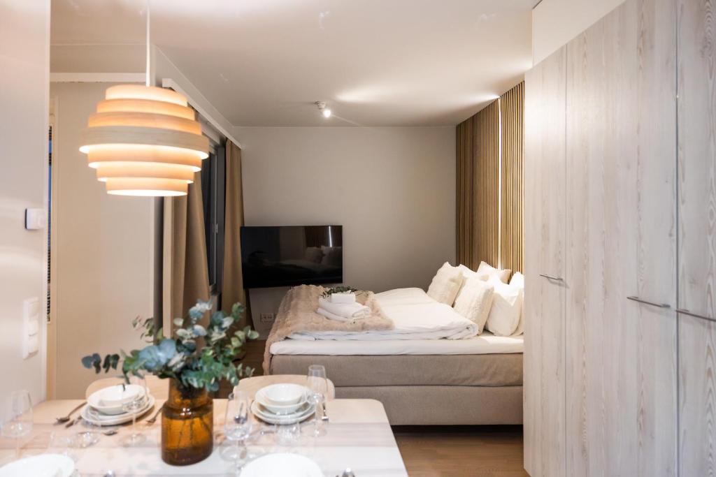 a hotel room with a bed and a table and a room at Arctic Honey City Suite in Rovaniemi