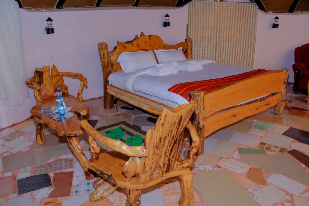 a bedroom with a wooden bed and a table at Enkapune Resort Naivasha in Naivasha