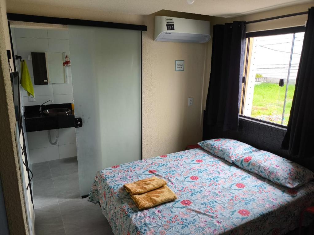 a bedroom with a bed and a sink and a window at Casa de Praia Família Próximo ao ExpoCentro BC in Balneário Camboriú