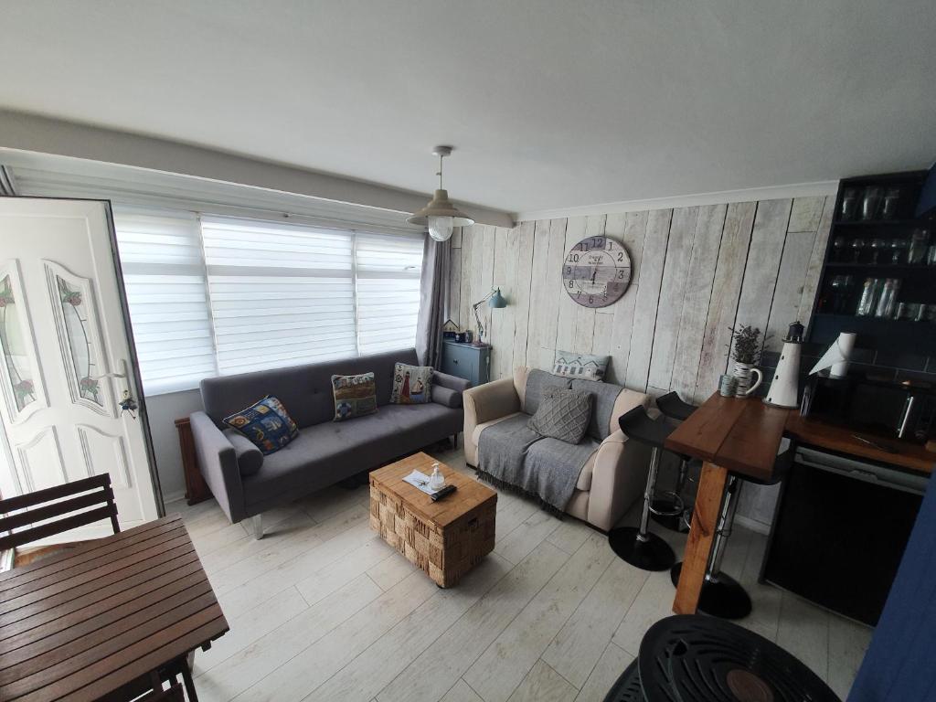 a living room with a couch and a table at California beachhut chalet in Great Yarmouth