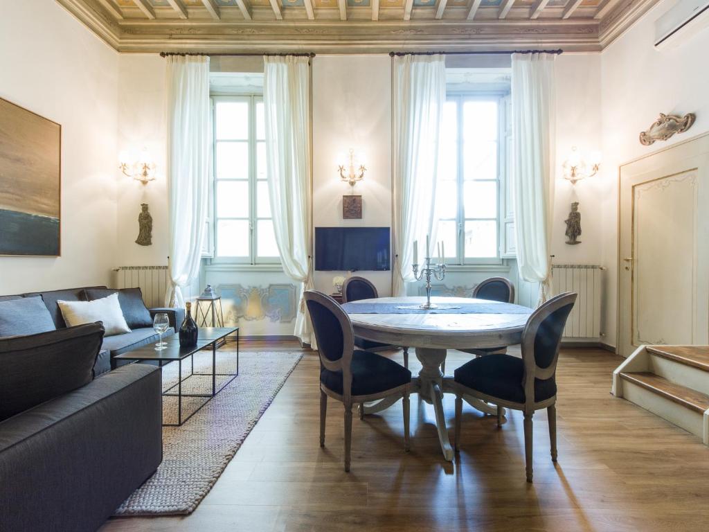 un soggiorno con tavolo, sedie e divano di Apartments Florence - Orsanmichele view a Firenze