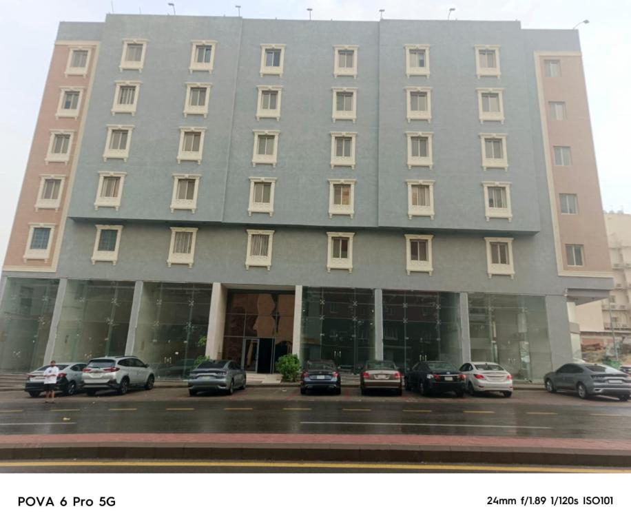 a large building with cars parked in a parking lot at أفخم شقة فندقيه بالقرب من الحرم المكي in Makkah