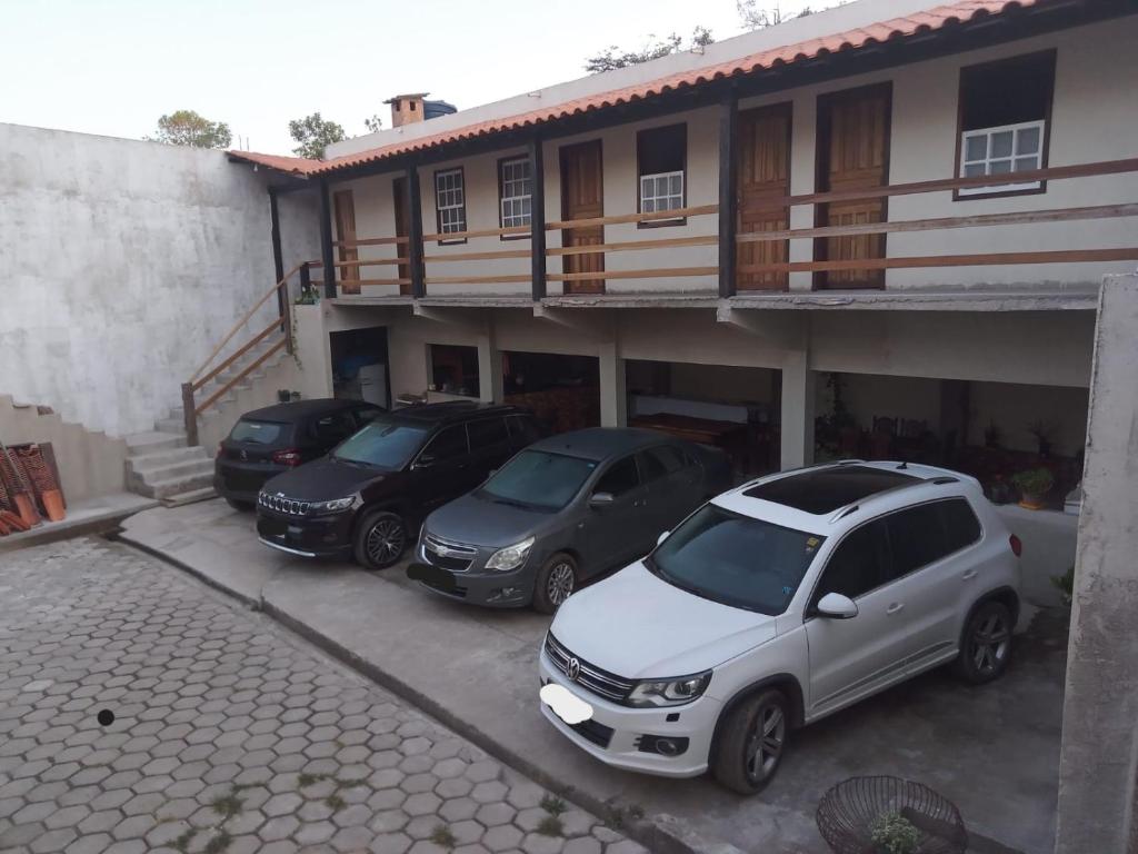 a group of three cars parked in front of a building at Vila a Arte de Minas in Tiradentes
