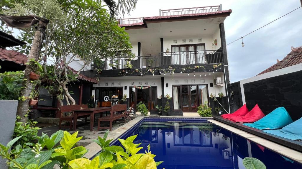 a villa with a swimming pool in front of a house at Parmilla Uluwatu in Uluwatu