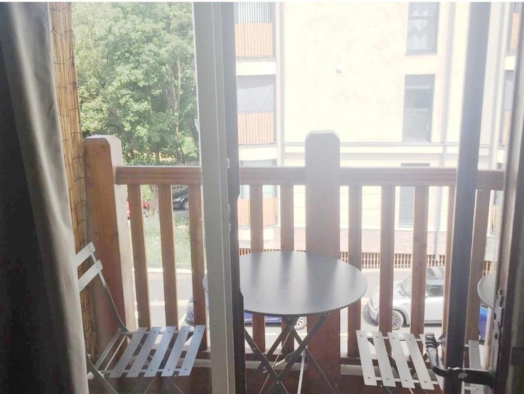 un porche avec une table et des chaises sur un balcon dans l'établissement Confortable studio, jolie terrasse a 350 m de Paris, à Gentilly