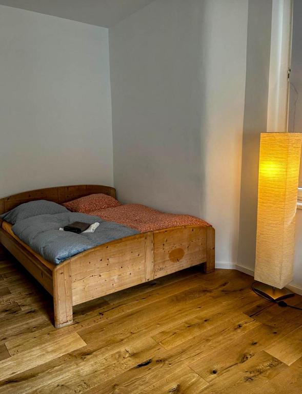 a bedroom with a wooden bed and a lamp at eigene Bad ruhig Öko Zentrum Zimmer Leipzig in Leipzig