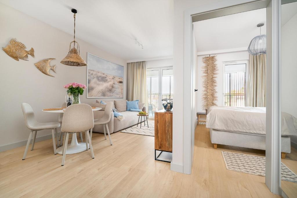 a bedroom and living room with a bed and a table at Your Holidays Baltic Waves B309 in Międzyzdroje