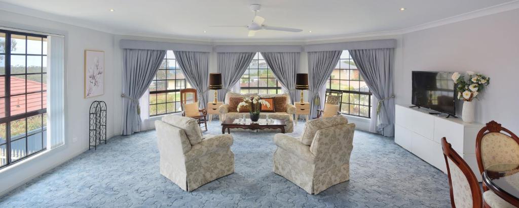 a living room with two chairs and a tv at Cozy on north in Armidale