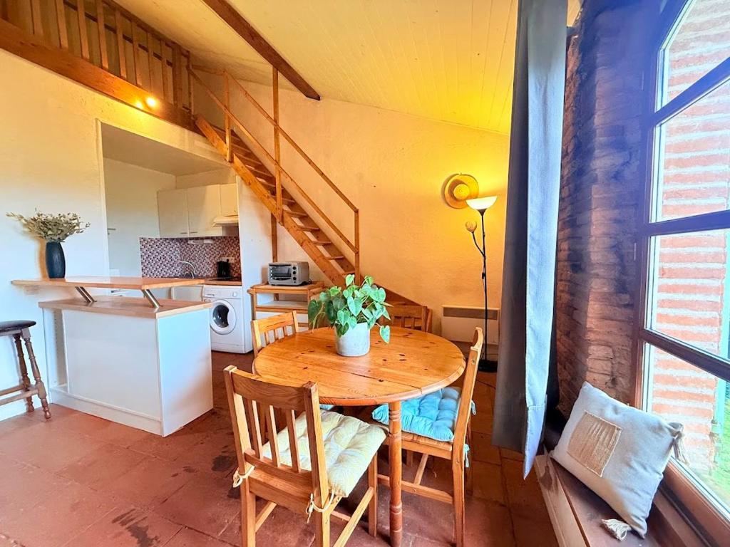 Villemur-sur-TarnにあるCocon paisible et confortable.のテーブルとキッチンのあるダイニングルーム