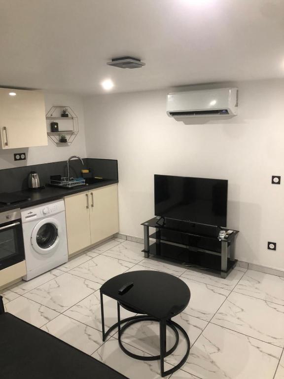 une cuisine avec un lave-linge et une chaise noire dans l'établissement Cozy and well located apartment, à Tremblay-en-France