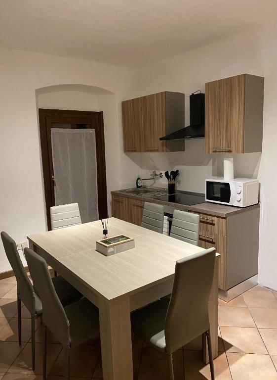 a kitchen with a table with chairs and a microwave at GolfHouseApartment in Bocenago