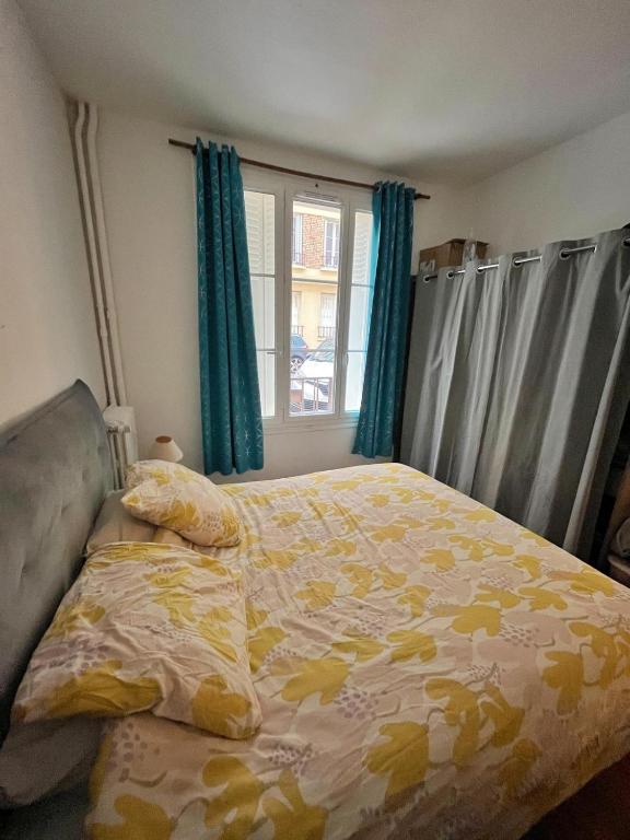 une chambre avec un lit et une fenêtre avec des rideaux bleus dans l'établissement Chambre Privée - Gentilly - France, à Gentilly