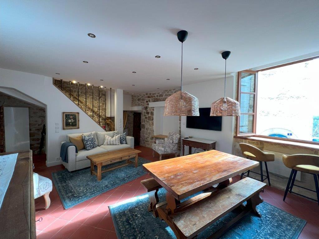 a living room with a table and a couch at Authentic Maison in Old Town in Forcalquier