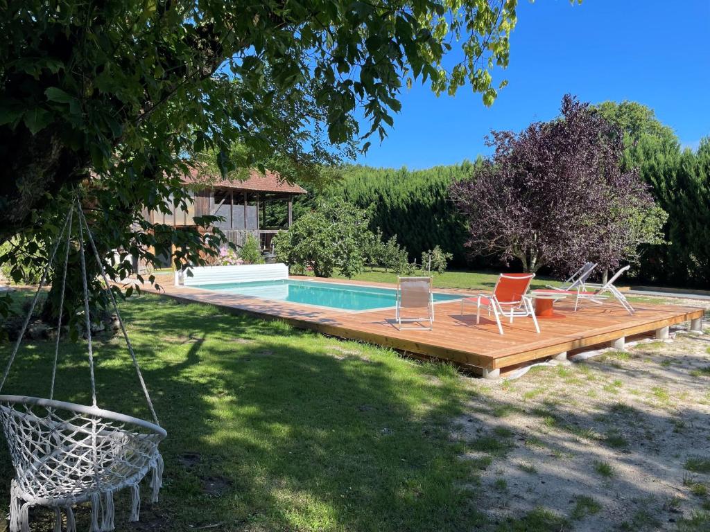 a deck with chairs and a swimming pool at INSTANT ZEN in Saint-Vivien-de-Médoc