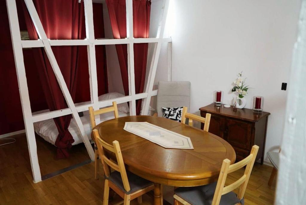 une salle à manger avec une table et des chaises en bois dans l'établissement Appartement typique Alsacien, à Strasbourg