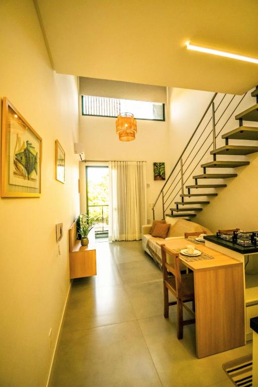 a living room with a table and a staircase at Loft Novo Campeche in Florianópolis