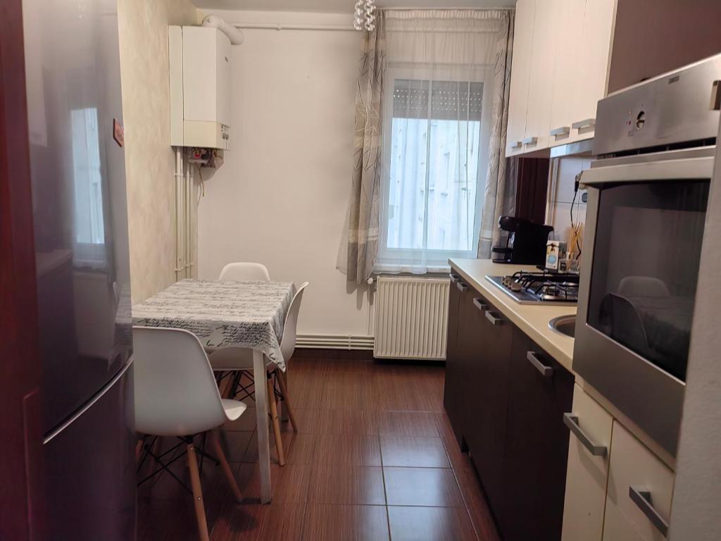 a kitchen with a table and a small table with chairs at Apartament Vultur - 3 rooms, 2 bathrooms in Târgu-Mureş