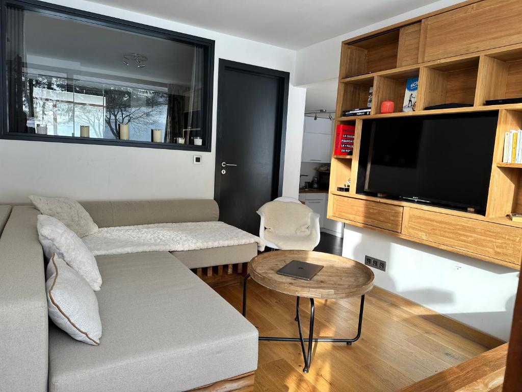 un salon avec un canapé et une télévision à écran plat dans l'établissement Arc 1800 - Les Lauzières Sud - Bel appartement double 6-8 personnes, à Arc 1800