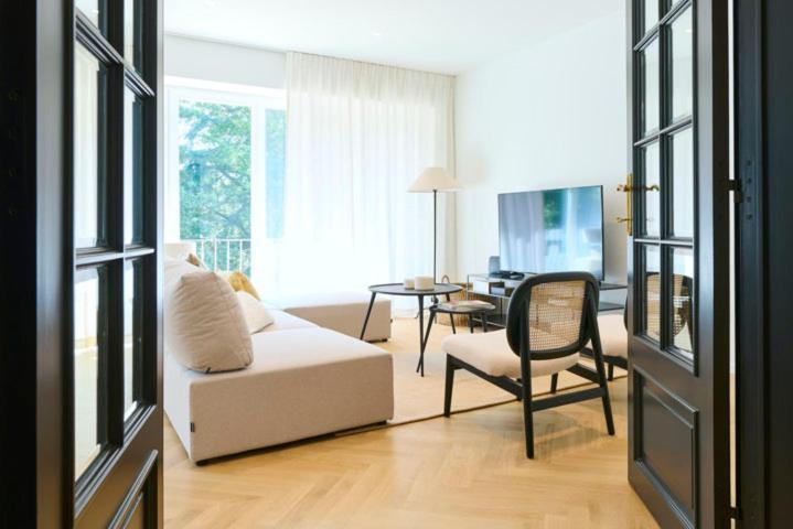 un salon avec un canapé blanc et une table dans l'établissement Chaleureux Appartement Reims, à Reims