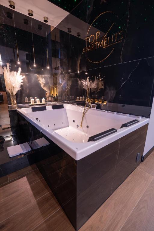 a bathroom with a bath tub with feathers on it at Apartament z jacuzzi, Wiślane Tarasy in Krakow