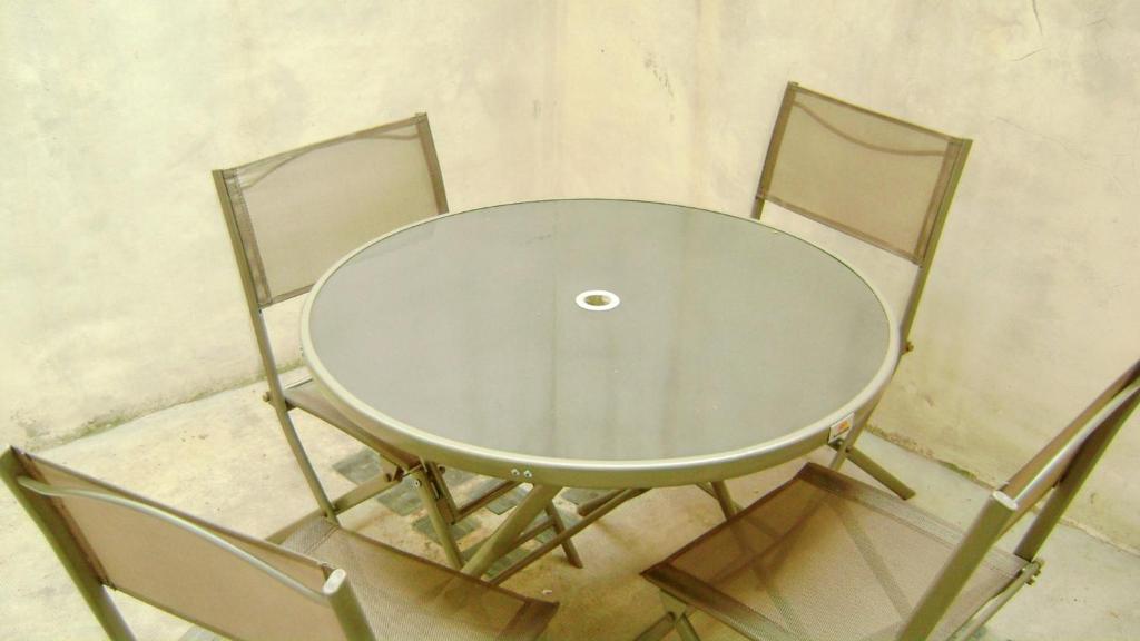 un tavolo di vetro con due sedie attorno di Maison charmante à Montblanc avec terrasse a Montblanc