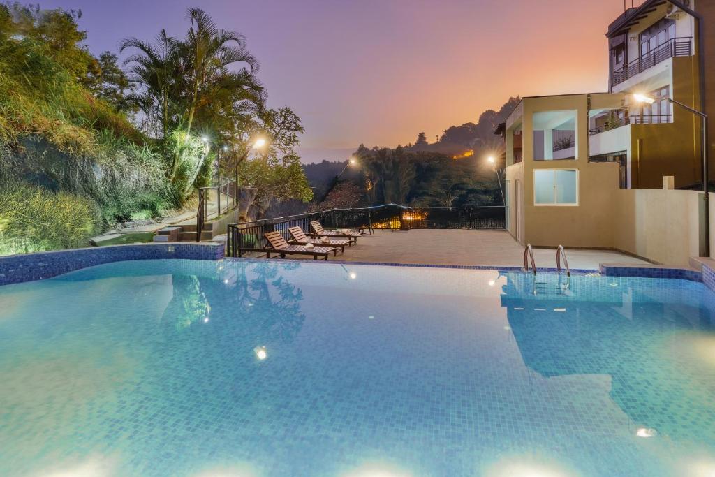 a large swimming pool in front of a house at Hotel Travellers Nest Kandy in Kandy