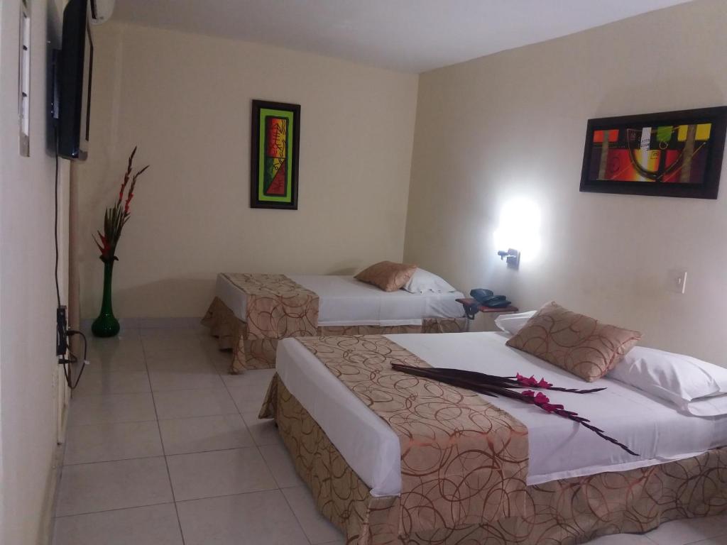 ネイバにあるHotel Tumburagua Inn Ltdaのベッド2台とテレビが備わるホテルルームです。