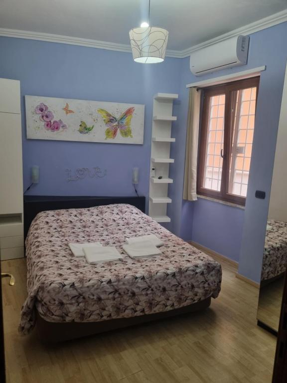 Un dormitorio con una cama en una habitación azul. en RED ROSE, en Roma