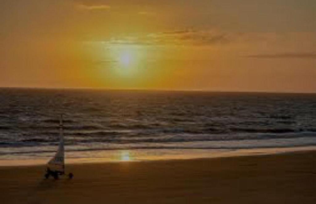 a sail boat on the beach at sunset at Recidencial Cruz del Mar "Duplex Villa Amanecer" in Chipiona