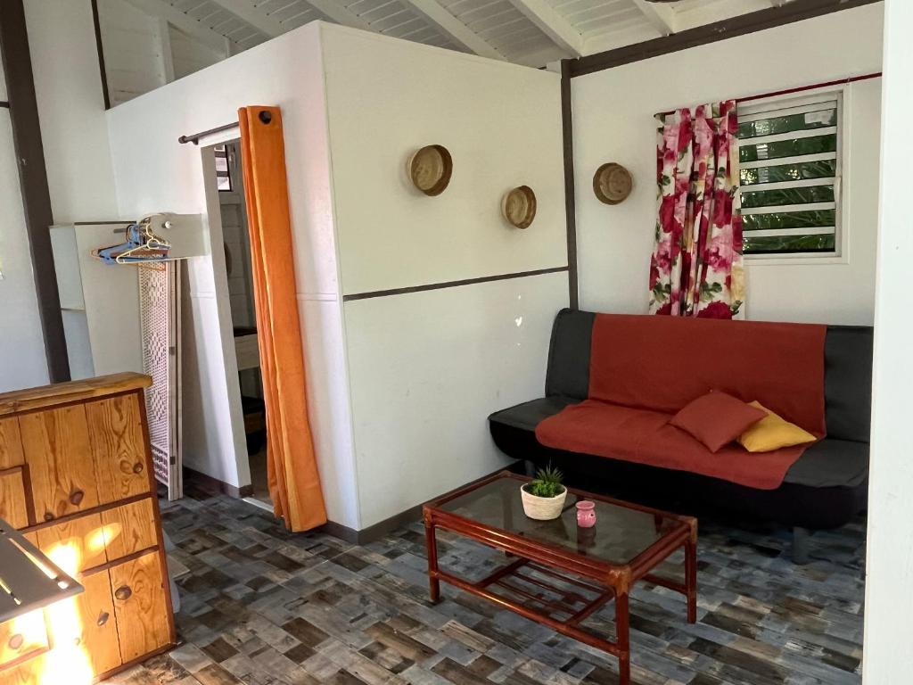 een woonkamer met een bank en een tafel bij LES BUNGALOWS DE LOUISIANE in Saint-François