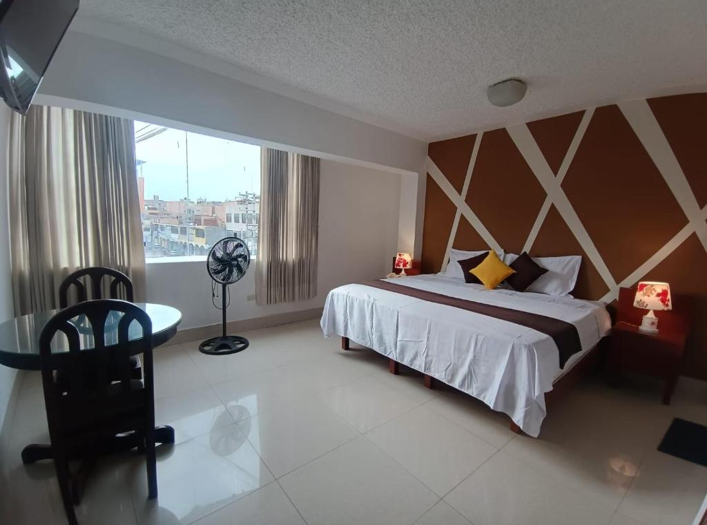 a bedroom with a large bed and a window at Silvana Hostal in Chiclayo
