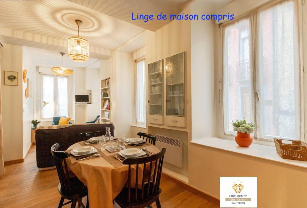 a dining room and living room with a table and chairs at Appartement cosy au cœur de la ville, au calme avec Wifi et linge de maison inclus in Cauterets