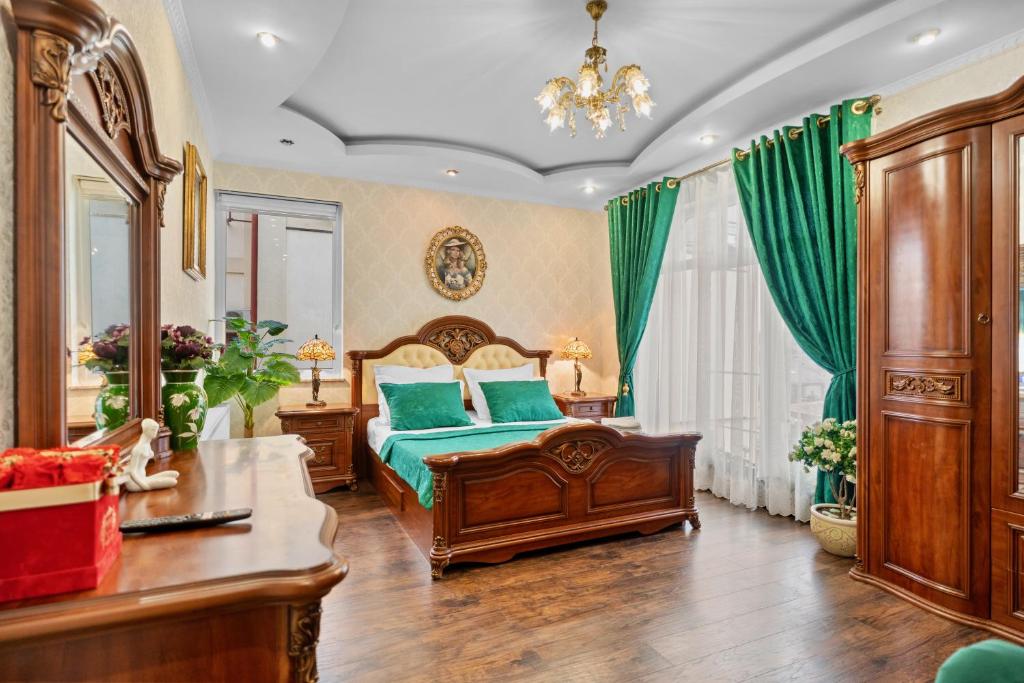 una camera da letto con un letto con lenzuola verdi e un lampadario a braccio di High-end 3BR Apartment - Private Garden, Terrace & BBQ a Bucarest