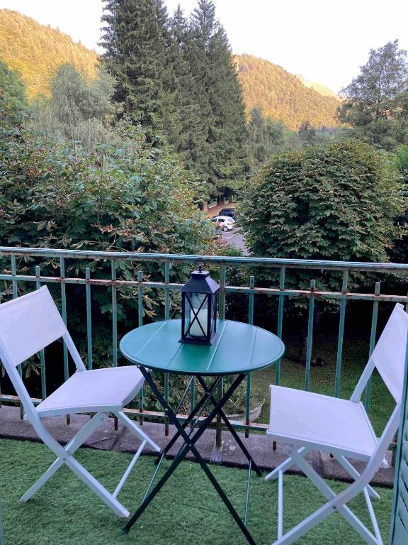 2 chaises et une table avec une lampe sur la terrasse dans l'établissement Nid douillet avec balcon, à Le Mont-Dore