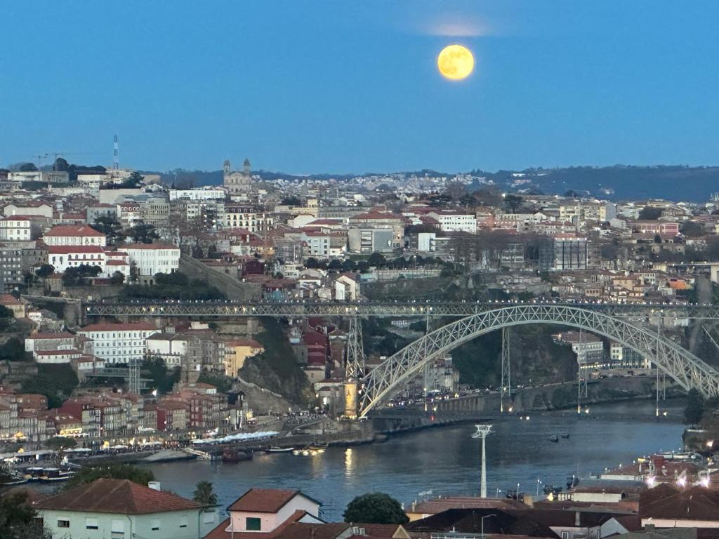 a view of a city with a bridge and the moon at New Douro 801 with shared pool and parking in Vila Nova de Gaia