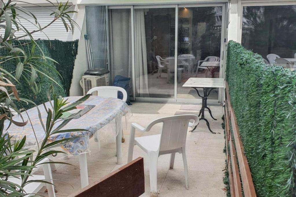 un patio avec une table et des chaises sur un balcon dans l'établissement Appartement charmant à La Grande-Motte de 37m² avec jardin, à La Grande Motte