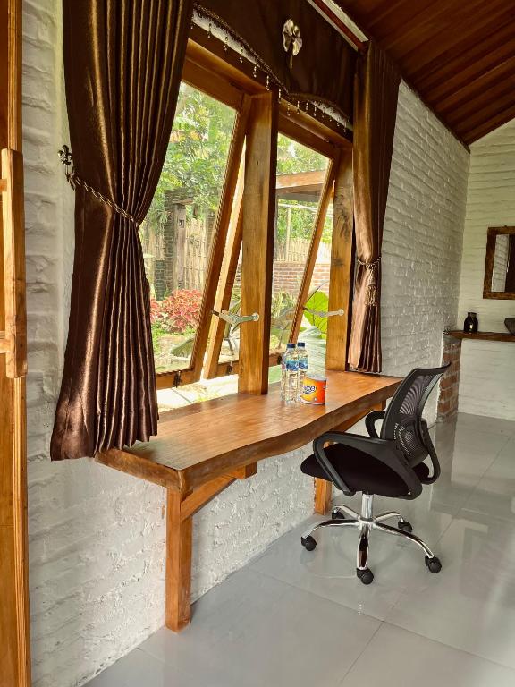 a desk with a chair in front of a window at Mimi homestay-LOMBOK in Tetebatu
