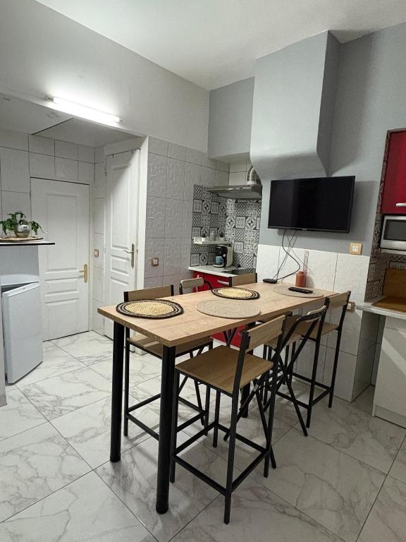 une cuisine avec une table et des chaises en bois dans l'établissement Maison de ville, à Beauvais