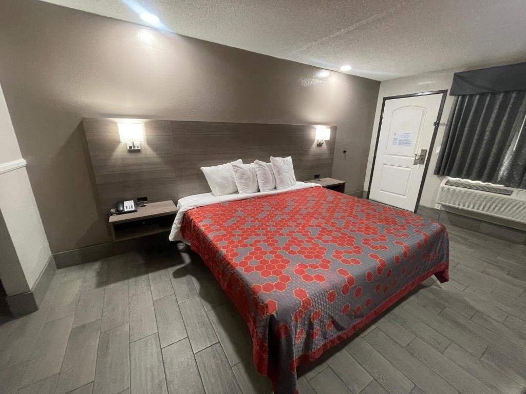 a hotel room with a bed with a red bedspread at SimpleStay Suites - Downtown San Bernardino in San Bernardino